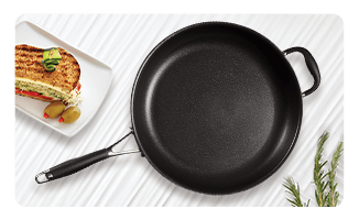 Non-stick pan alongside a grilled sandwich and fresh Rosemary herb